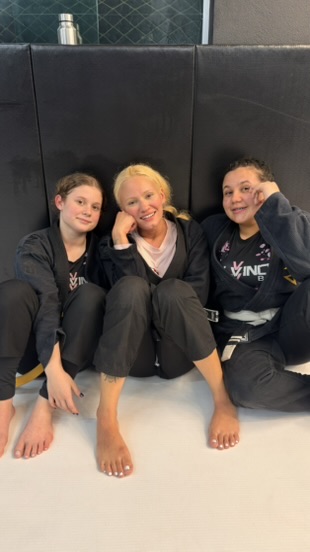 Três alunas da Salvino BJJ sentadas no tatame